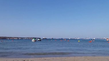 Scooter ve tekneler ve deniz unrecognisable insanlar küçük dalgalar Mellieha, Malta, kum plajındaki su