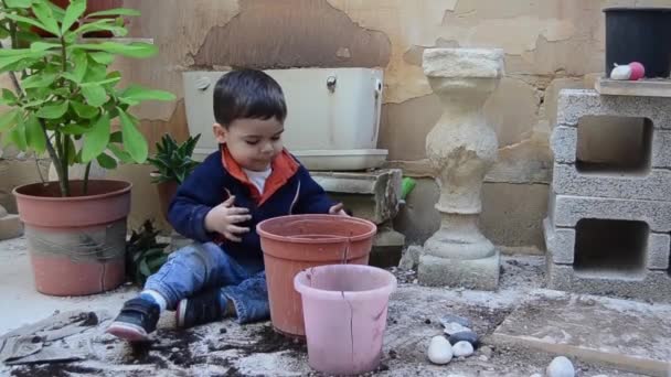 Niño de un año y medio jugando con tierra — Vídeo de stock