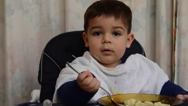 Un bambino di un anno e mezzo che mangia zuppa con cucchiaio da solo — Video Stock