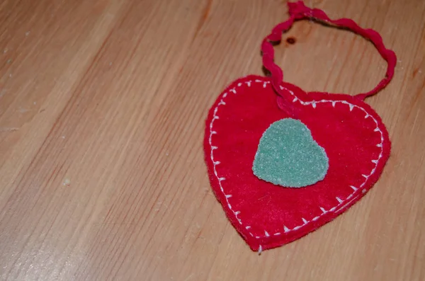 Hart van de stof op de houten tafel met hart vormige groene snoep bovenop — Stockfoto