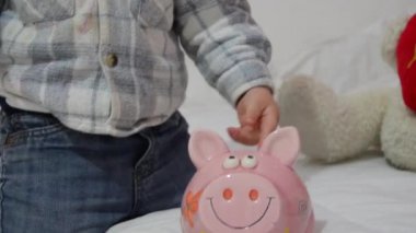 sevimli iki yıl içinde kumbara ile oynama ve koyarak eski bebek çocuk paraları