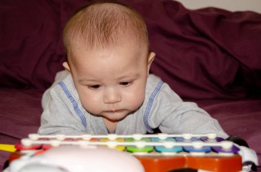 Karın vakit geçiriyor ve renkli ksilofon - mutlu çocukluk kavramı bakarak şirin 4 aylık erkek bebek