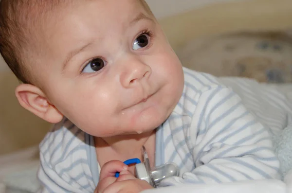 Carino 4 mesi vecchio bambino avendo pancia tempo e fare divertente facce — Foto Stock