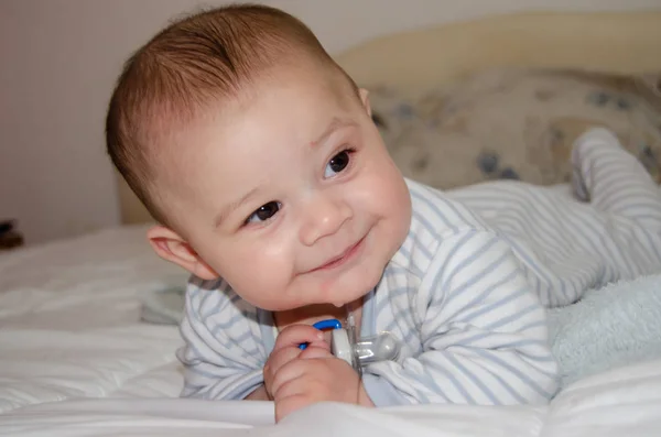 Carino 4 mesi vecchio bambino avendo pancia tempo e fare divertente facce — Foto Stock