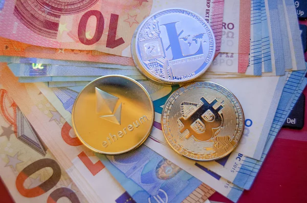 Bitcoin litecoin et éthérie version phisical de pièces virtuelles sur l'euro papier-monnaie — Photo
