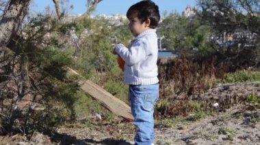Toddler ağaçlar ile Seacoast üzerinde kamera doğru yürüyüş
