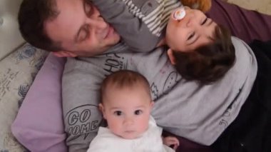 Baba ve iki oğul, Bebek ve Toddler, yatakta birlikte oynuyor
