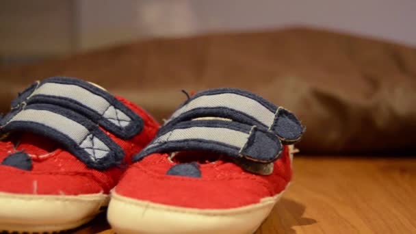 Следящий снимок детской обуви на столе — стоковое видео