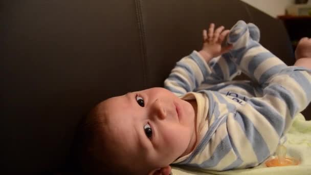 Gros plan prise de vue aérienne de bébé garçon sur la soffa jouer avec ses pieds — Video