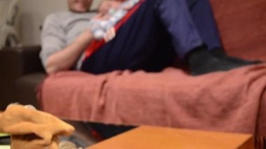 Baba, bebek oyuncaklarla oynarken altı aylık oğlunu tutuyor. Odak değiştirme çekimi