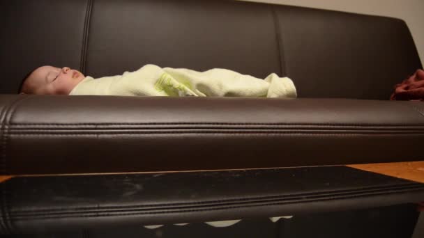 Madre limpieza mesa de café whille bebé está durmiendo en el sofá — Vídeos de Stock