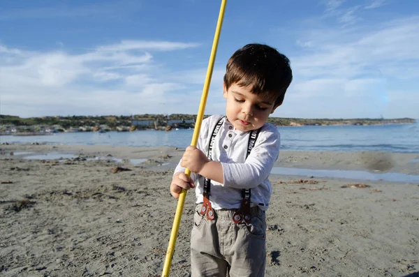 Lindo niño de dos años jugando con la red de pesca en el día soleado en la playa del mar —  Fotos de Stock