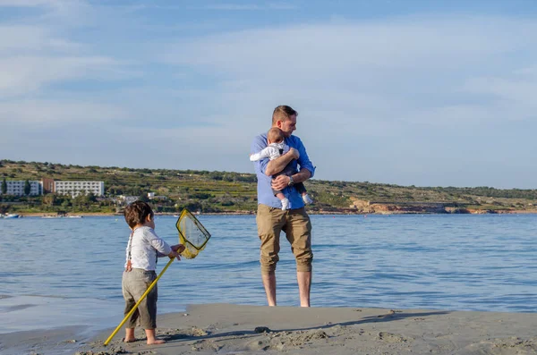 Padre e bambino e bambino che giocano sulla spiaggia di sabbia — Foto Stock