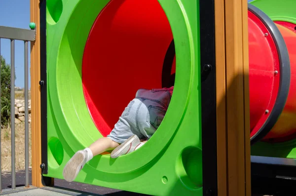 Lindo niño de dos años de edad playig en el parque infantil al aire libre en el túnel —  Fotos de Stock