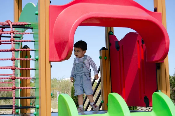Niedlichen zwei Jahre alten Jungen Spielwiese auf dem Kinderspielplatz im Freien auf dem Spielhaus — Stockfoto