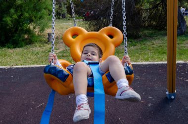 Sevimli iki yaşındaki çocuk oyun oyun açık oyuncak ayı salıncak üzerinde playig