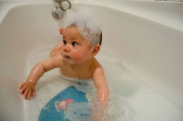 Lindo niño de seis meses teniendo un baño espumoso en su barriga — Foto de Stock