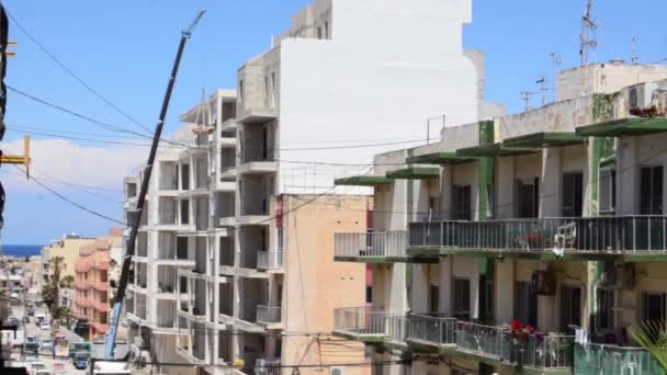 Qawra, Malta 14. mayo 2019 - Trabajadores de la construcción en el sitio, levantador de bolsas con cemento en la flor superior — Vídeos de Stock