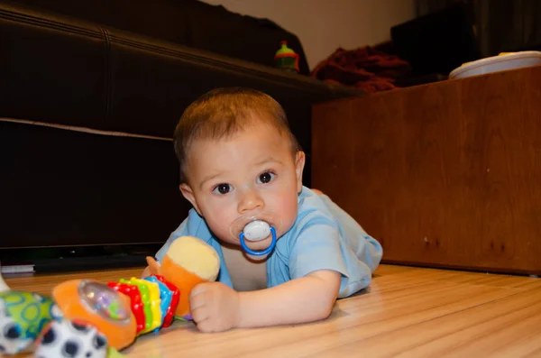 Bonito menino de seis meses de idade brincando na flor com brinquedo de dentição, desenvolvimento precoce e conceito de dentição — Fotografia de Stock
