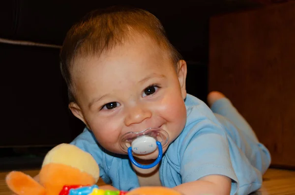 かわいい6ヶ月の男の子が歯のおもちゃで花の上で遊んで、早期開発と歯の概念 — ストック写真