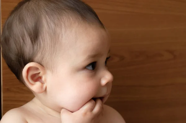 Retrato rosto expresão de bonito seis meses de idade menino colocando o dedo em sua boca dentição problemas — Fotografia de Stock