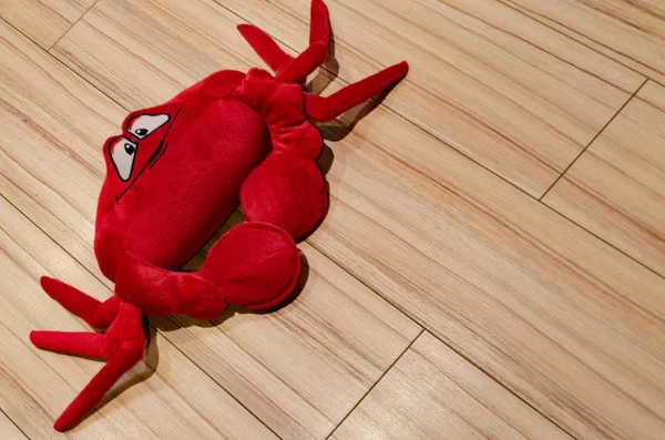 Caranguejo de brinquedo macio vermelho no chão de madeira — Fotografia de Stock