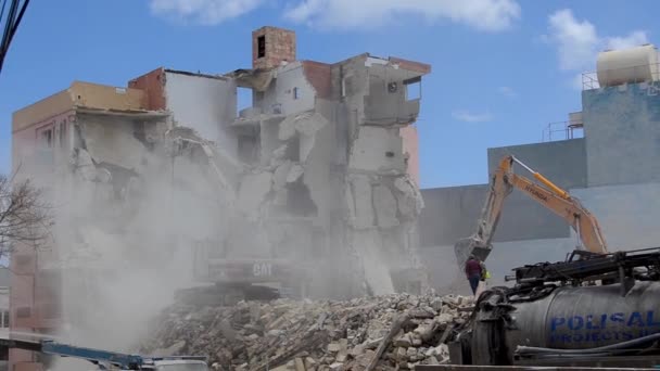 Qawra, Malta 16 de mayo de 2019 - Segundo día de demolición del antiguo hotel Qawra Inn - demoler edificios con excavadoras y supervisores no lleva ropa protectora ni cascos — Vídeo de stock