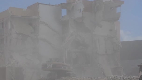 カウラ、マルタ16。2019年5月 - 古いQawra Innホテルの解体2日目 - 掘削機と監督者が防護服やヘルメットを着用していない建物を取り壊す — ストック動画