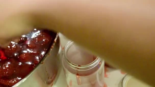 Frau legt handgemachte Erdbeermarmelade ins Glas — Stockvideo