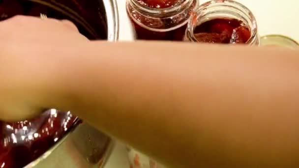 Frau legt handgemachte Erdbeermarmelade ins Glas — Stockvideo