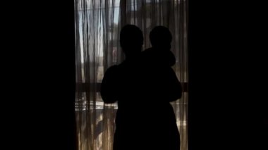 hamile anne ve altı aylık bebek silueti - anne öpüşme kaldırma ve küçük bebek spining