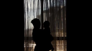 hamile anne ve altı aylık bebek silueti - anne öpüşme kaldırma ve küçük bebek spining