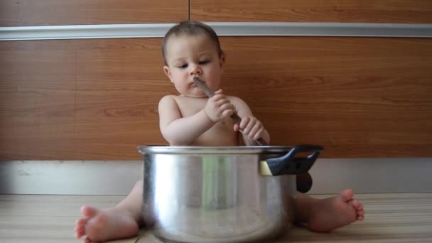 요리 냄비와 나무 숟가락으로 놀고 귀여운 6 개월 오래 된 아기 소년 — 비디오