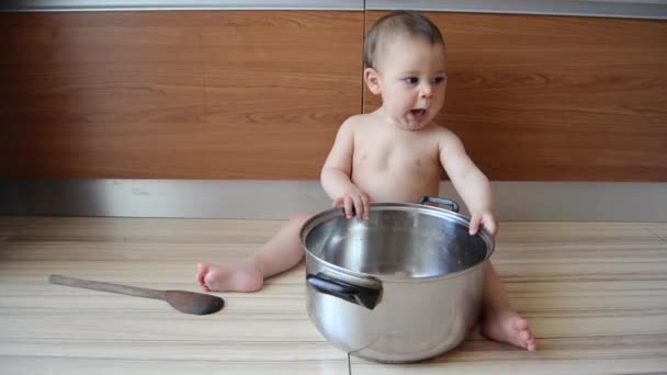 Söt sex månader gammal pojke leker med Kok kärl och trä sked gäspningar — Stockvideo