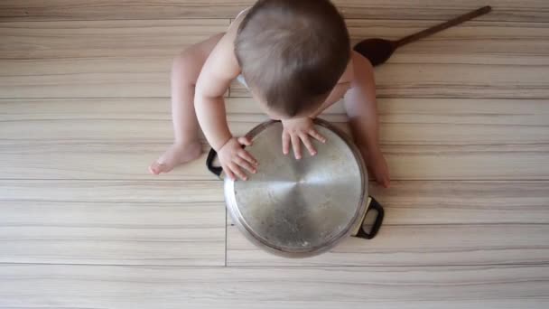 Χαριτωμένο έξι μηνών μωρό αγόρι παίζει με το μαγείρεμα Pot και ξύλινη κουτάλα — Αρχείο Βίντεο