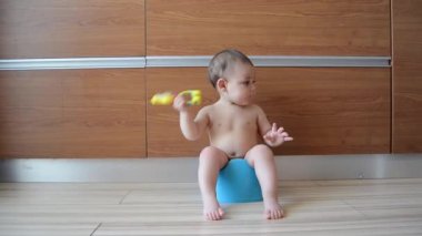 sevimli altı ay eski bebek oğlan oturan üzerinde bu lazımlık ve oyun ile diş çıkarma oyuncak