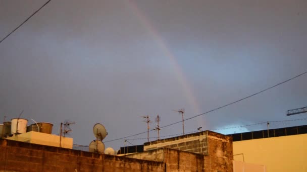 Buggiba, Malta 30. mei 2019 Rainbow ower residentiële gebouwen op donkere bewolkt regenachtig stormachtige dag — Stockvideo
