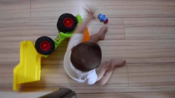 Alto ángulo giratorio tiro, lindo niño de siete meses jugando con juguetes educativos en el suelo — Vídeo de stock