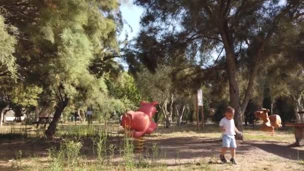 Aranyos két éves fiú fut az üres parkban. Társadalmi távolság, 2020 — Stock videók