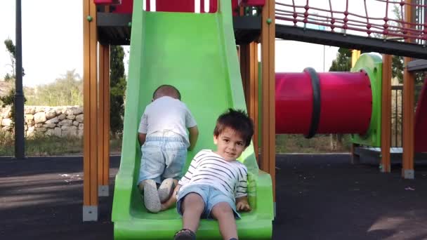 Nette Kinder, Brüder, die auf dem Spielplatz spielen. Zeitlupe — Stockvideo