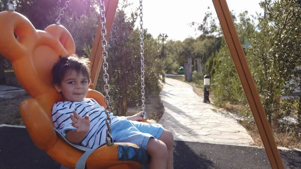 Adorable niño, preescolar balanceándose en el columpio en un parque vacío —  Fotos de Stock
