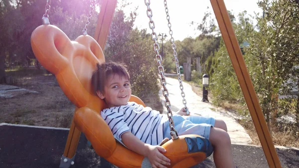 Adorable niño, preescolar balanceándose en el columpio en un parque vacío —  Fotos de Stock