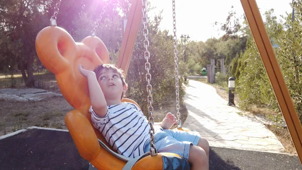 Adorable niño, preescolar balanceándose en el columpio en un parque vacío —  Fotos de Stock