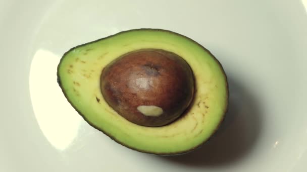 Hand tar avokado från den vita plattan, slow motion — Stockvideo