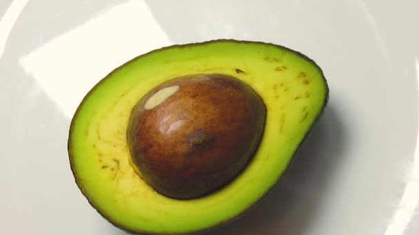 Avocado on the white plate, close up — стоковое видео