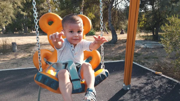 Adorable niño en un columpio con una gran sonrisa en su cara — Foto de Stock