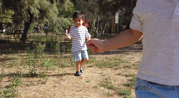 Carino bambino di due anni e suo fratello di quattro anni che corre nel parco vuoto. Distanze sociali, 2020 — Foto Stock