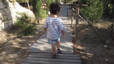Parktaki ahşap verandada yürüyen 4 yaşında tatlı bir çocuk.. 