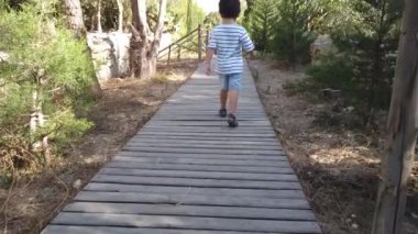 Parktaki ahşap verandada yürüyen 4 yaşında tatlı bir çocuk.. 
