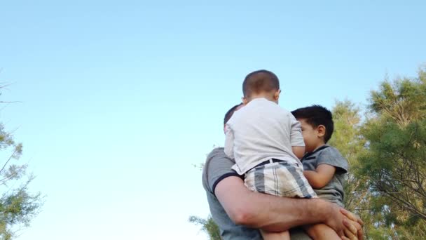 Щаслива молода сім'я. Батько обертається навколо своїх синів. Низький кут — стокове відео